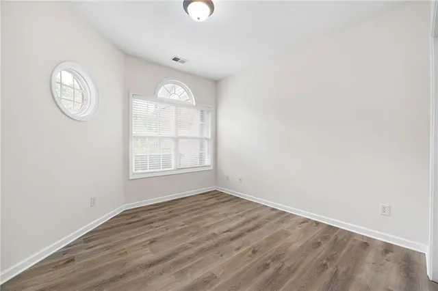 an empty room with wooden floor and a window