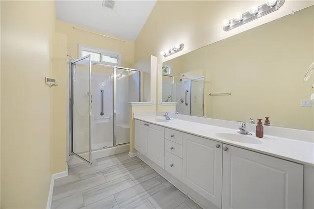 a bathroom with a double vanity sink mirror and shower