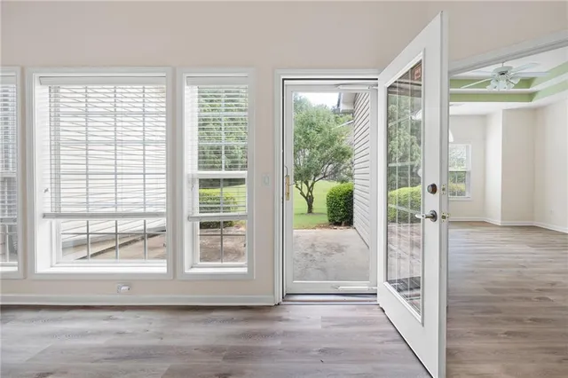 a view of a hallway with wooden floor and windows