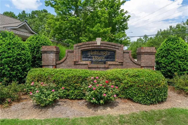 a view of a garden with a bench in front of the house