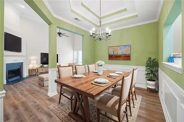 a view of a dining room with furniture a fireplace and wooden floor
