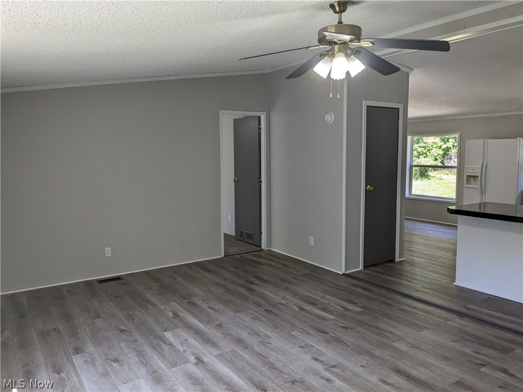 73455 Seminary Road Kimbolton, OH 43749 - Photo 6 of 28 Unfurnished living room featuring crown molding, wood-type flooring, and ceiling fan
