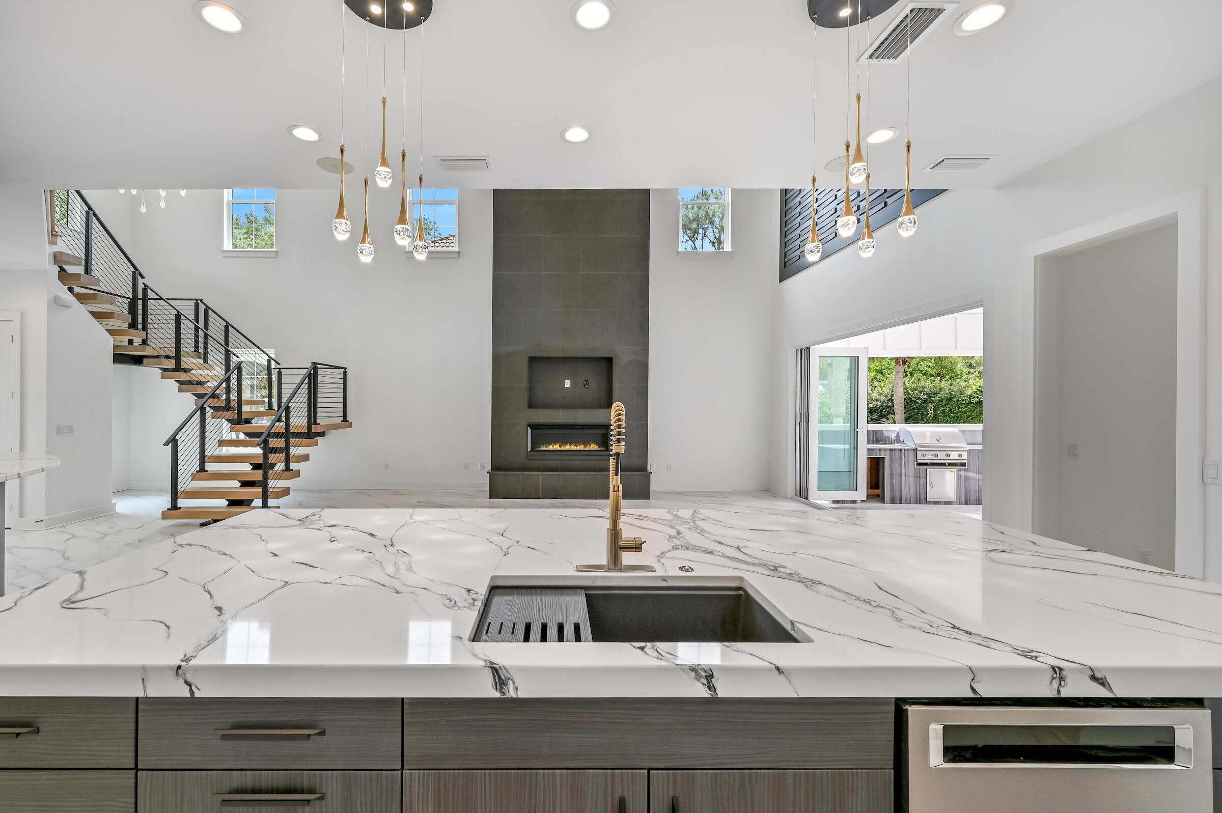 80 Rue Martine Miramar Beach, FL 32550 - Photo 20 of 54 a kitchen with kitchen island granite countertop a sink a counter top space and living room view