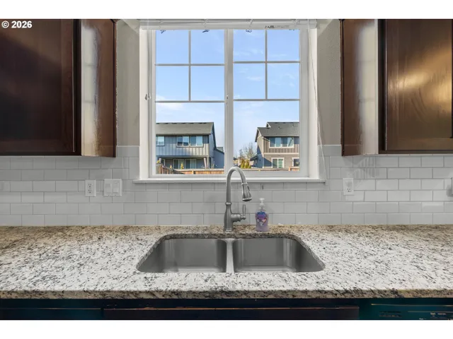 a kitchen with granite countertop a sink and a stove