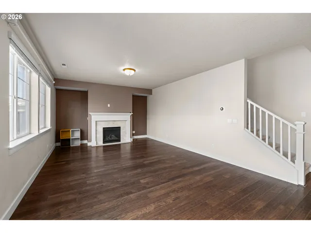 a view of empty room with wooden floor and fireplace