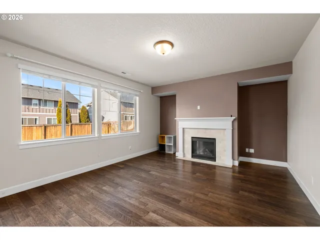 a view of an empty room with a window and fireplace
