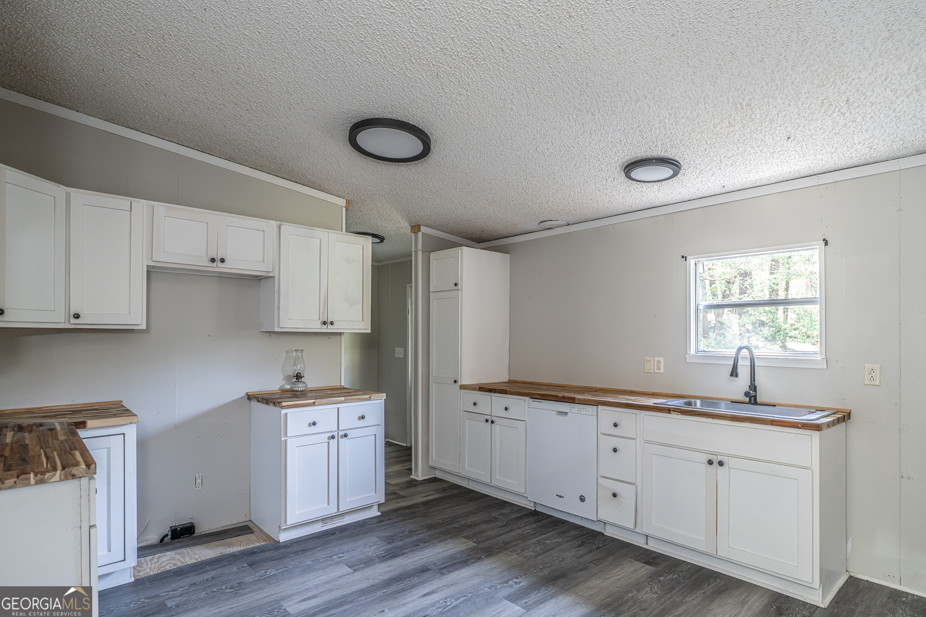 71 Kirk Road Northwest White, GA 30184 - Photo 10 of 43 a kitchen with a sink dishwasher a stove and white cabinets with wooden floor