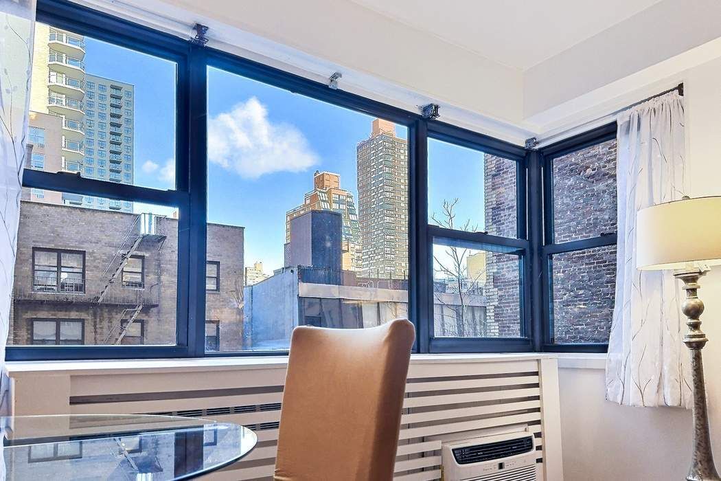 305 East 72nd Street, Unit 5AS Manhattan, NY 10021 - Photo 4 of 11 a room with furniture and a window