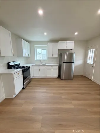 a kitchen with a refrigerator a stove top oven a sink and dishwasher