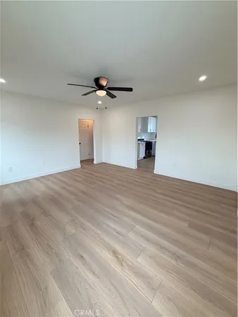 a view of an empty room with a chandelier fan