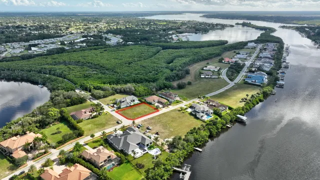 an aerial view of a city with lots of residential buildings ocean and mountain view in back