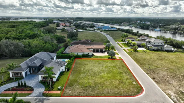 an aerial view of a residential houses with outdoor space and lake view