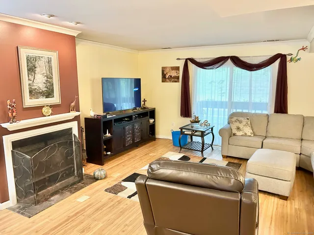 a living room with furniture a fireplace and a flat screen tv