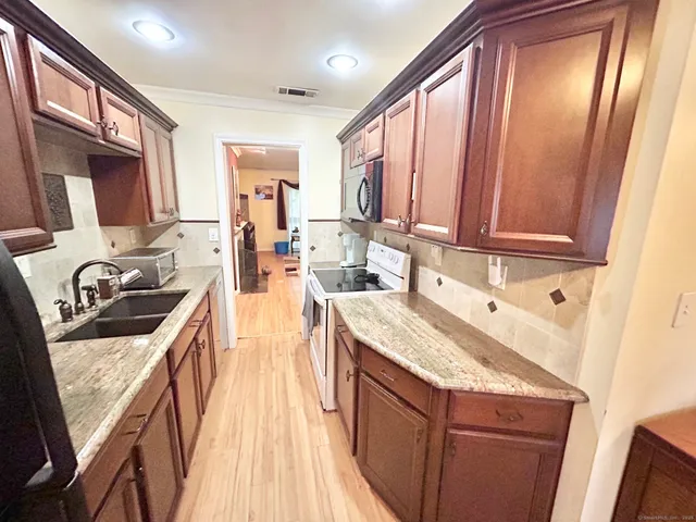 a kitchen with stainless steel appliances granite countertop a sink stove and refrigerator