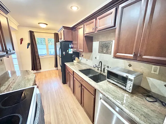 a kitchen with stainless steel appliances granite countertop a sink stove and refrigerator