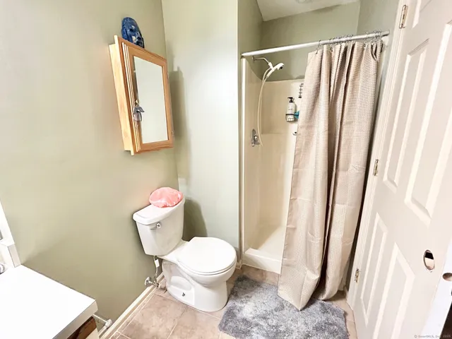 a white toilet sitting next to a bathroom sink and a shower