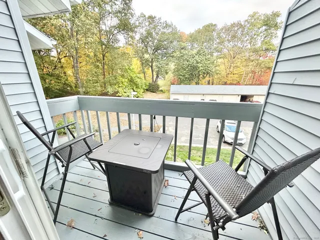 a view of a balcony with wooden floor and outdoor seating