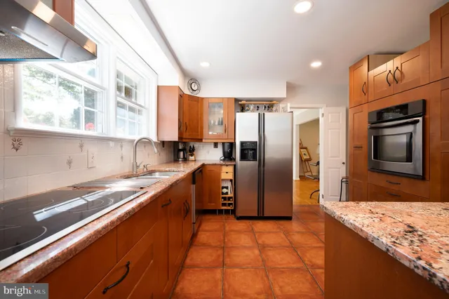 a kitchen with stainless steel appliances granite countertop a refrigerator and a sink