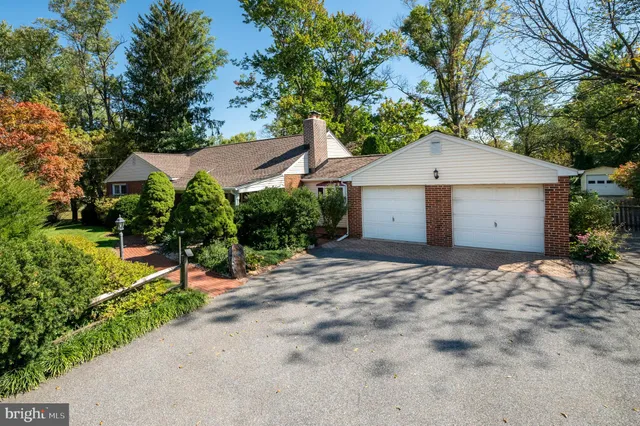 a view of a house with a yard and large tree