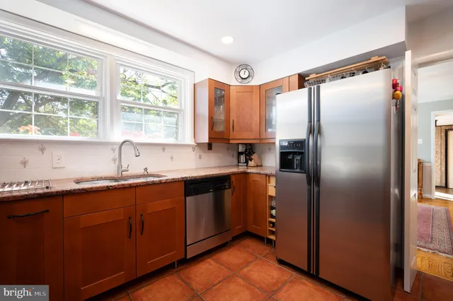 a kitchen with stainless steel appliances granite countertop a refrigerator and a sink