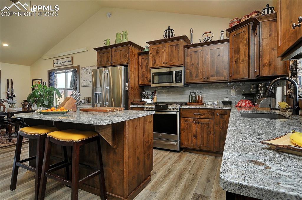 114 3rd Street Silver Cliff, CO 81252 - Photo 9 of 23 a kitchen with stainless steel appliances granite countertop a stove top oven a sink dishwasher and cabinets with wooden floor
