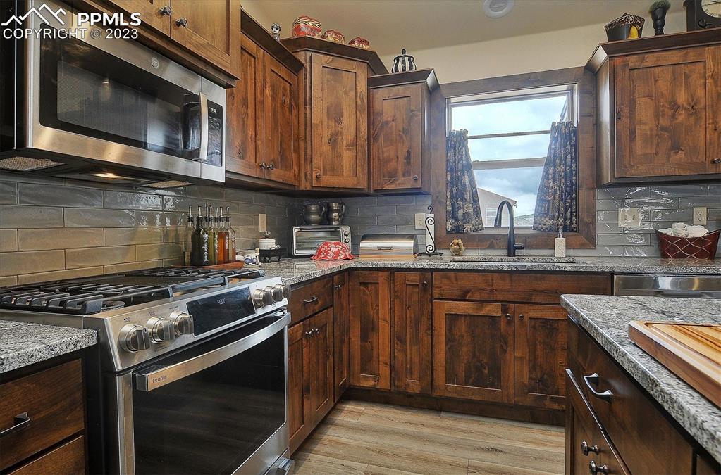 114 3rd Street Silver Cliff, CO 81252 - Photo 10 of 23 a kitchen with stainless steel appliances granite countertop a stove microwave and sink