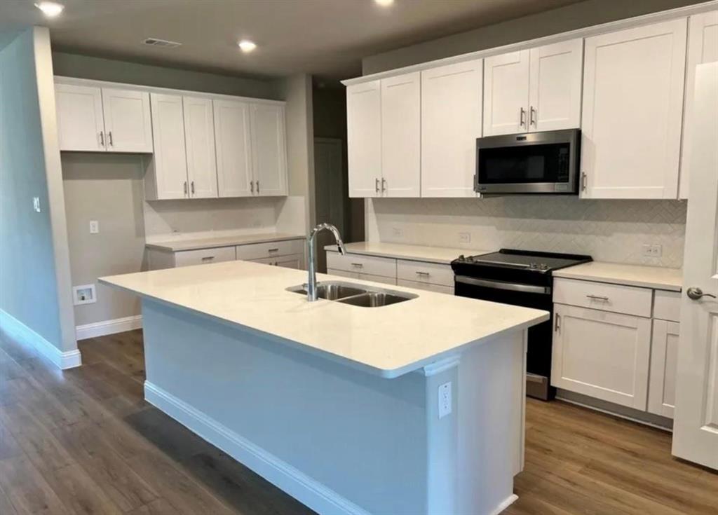 1510 Crystal Vly Way Melissa, TX 75454 - Photo 8 of 24 a kitchen with stainless steel appliances a sink a stove a microwave and cabinets
