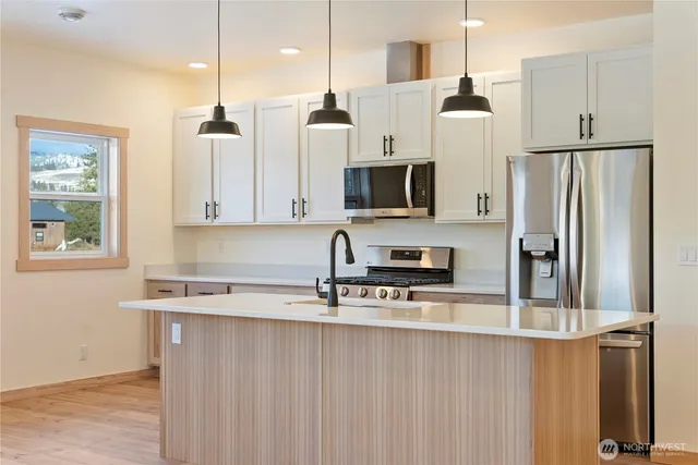 a kitchen with stainless steel appliances a refrigerator sink and microwave