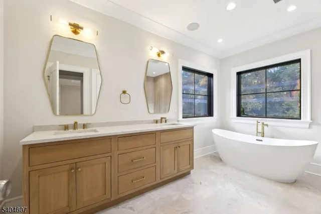 a bathroom with a double vanity sink mirror and bathtub
