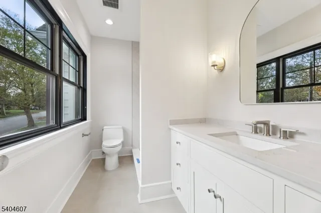 a bathroom with a toilet a sink and a large mirror