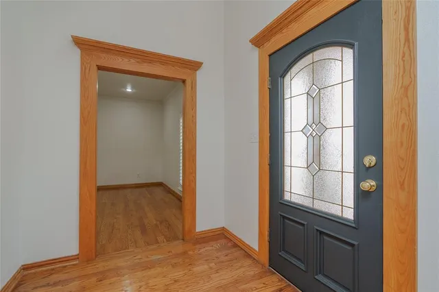 an empty room with wooden floor closet and windows