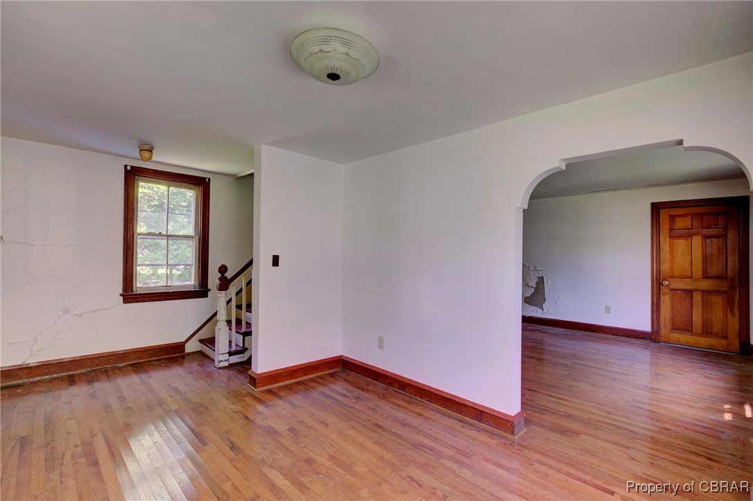 708 Calthrop Neck Road Yorktown, VA 23693 - Photo 8 of 24 Unfurnished room with light wood-style floors, arched walkways, and stairs