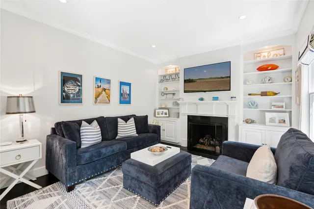 a living room with furniture a flat screen tv and a fireplace