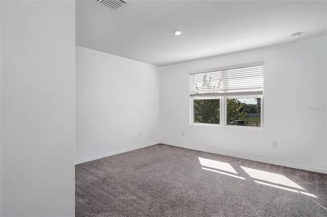 a bed sitting in a bedroom next to a window