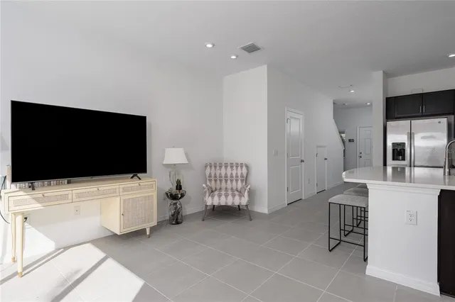 a kitchen with stainless steel appliances kitchen island granite countertop a sink a stove a dining table and chairs