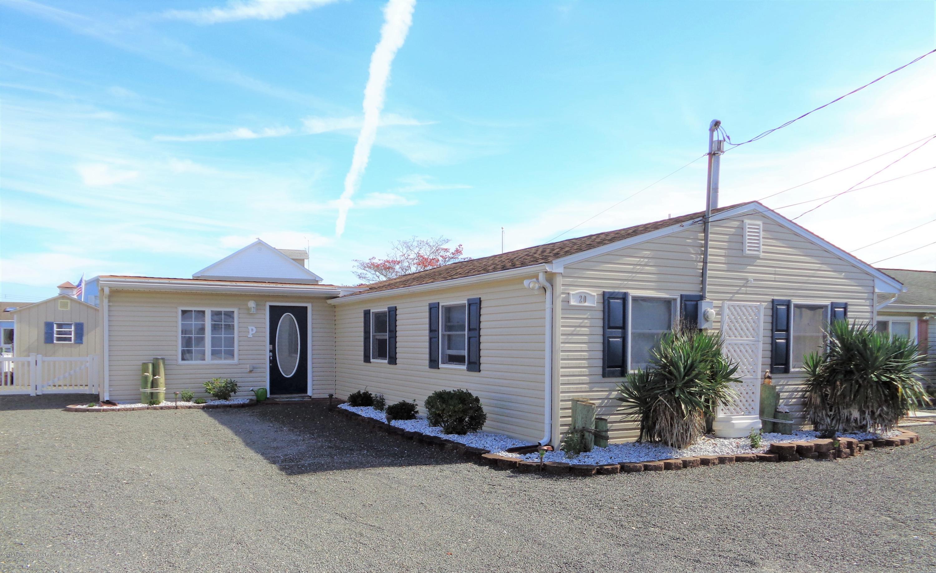 20 Capstan Road Waretown, NJ 08758 - Photo 2 of 25 a front view of a house with a yard and potted plants