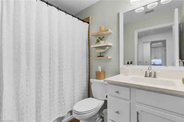 a bathroom with a toilet a sink and a mirror