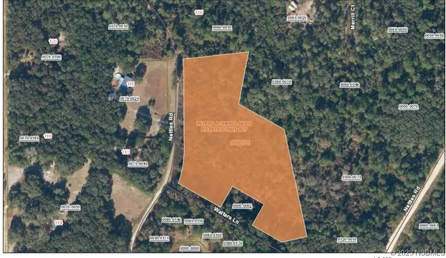 an aerial view of a house with a yard and trees