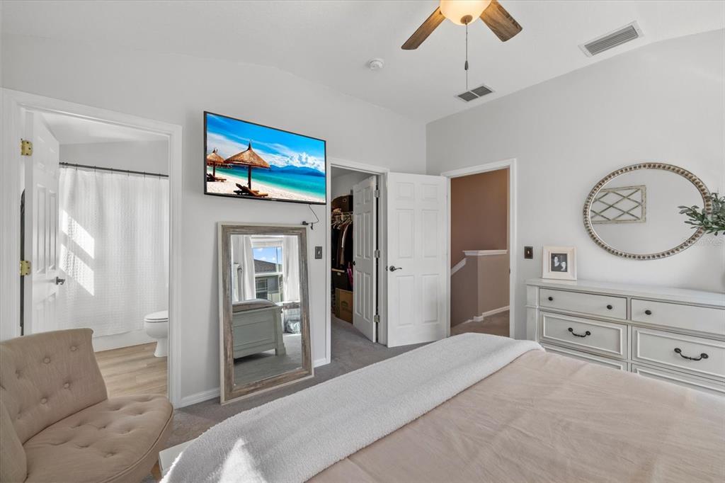 14932 Amberjack Terrace Lakewood Ranch, FL 34202 - Photo 19 of 45 a spacious bedroom with a bed and a chandelier