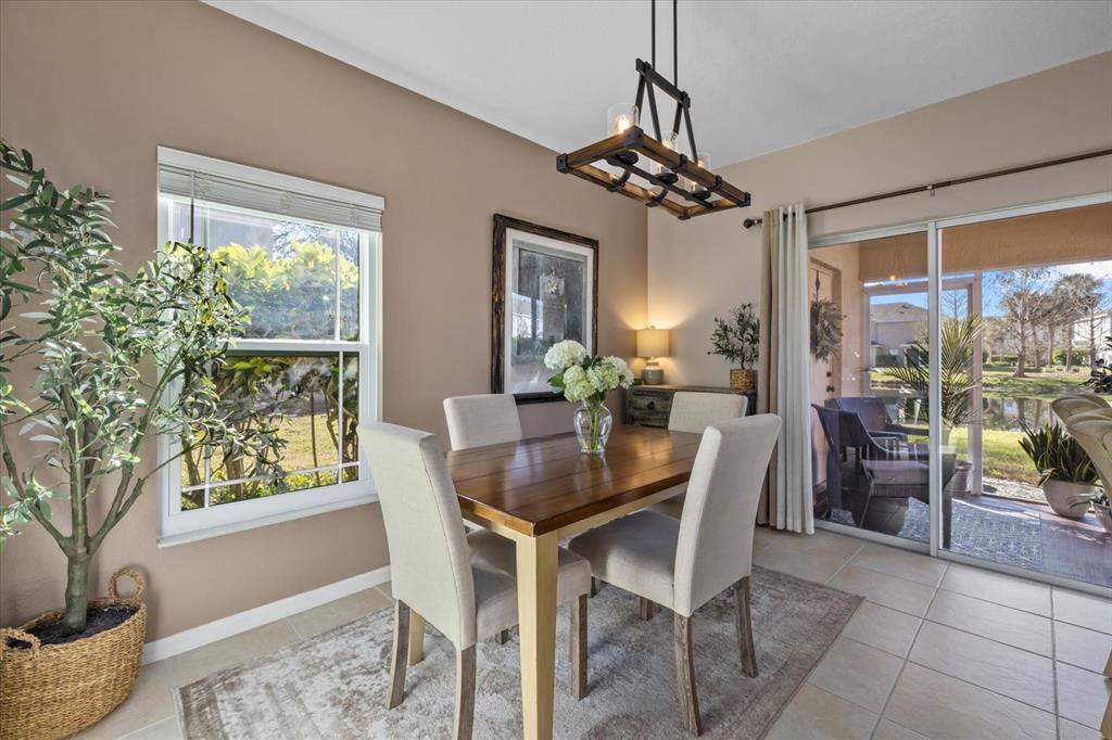 14932 Amberjack Terrace Lakewood Ranch, FL 34202 - Photo 9 of 45 a dining room with furniture a chandelier and wooden floor
