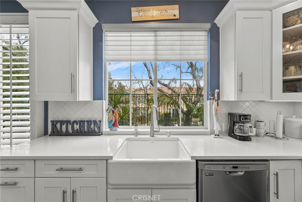 545 Lorabel Way, Unit D Simi Valley, CA 93065 - Photo 19 of 34 a kitchen with kitchen island a sink a stove and white cabinets next to a window