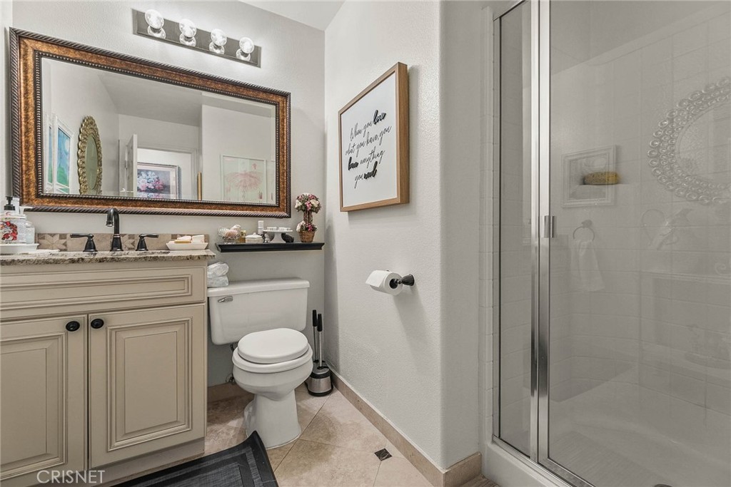 545 Lorabel Way, Unit D Simi Valley, CA 93065 - Photo 24 of 34 a bathroom with a granite countertop toilet a sink and a mirror