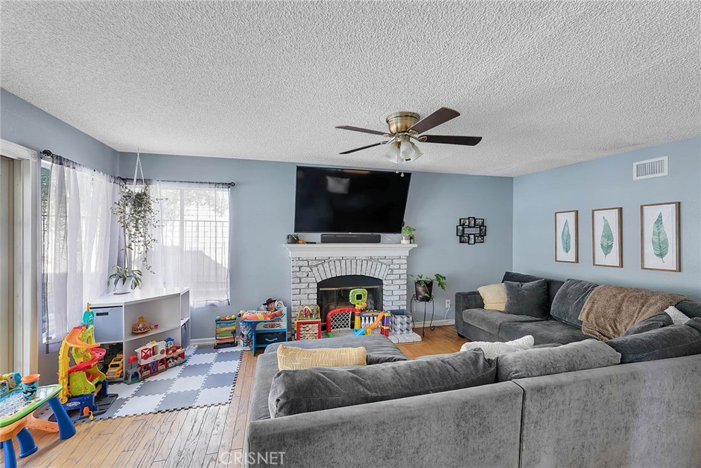 545 Lorabel Way, Unit D Simi Valley, CA 93065 - Photo 6 of 34 a living room with furniture a fireplace and a flat screen tv