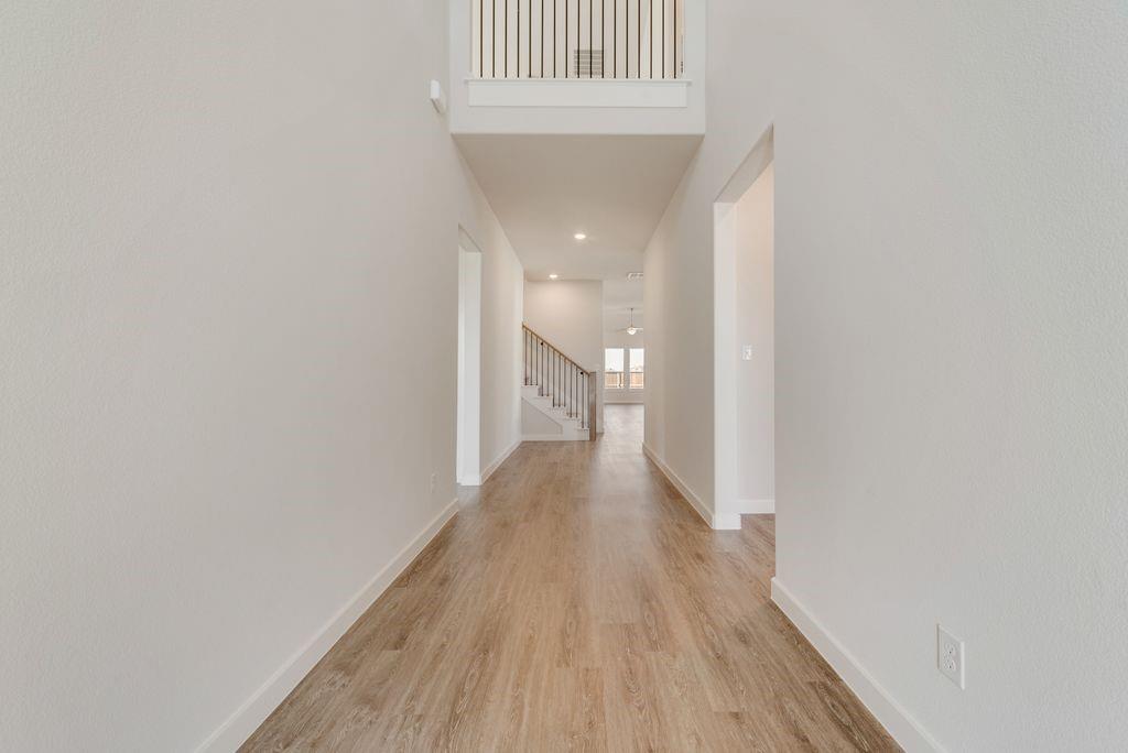 418 Bassett Hall Road Fate, TX 75189 - Photo 3 of 32 a view of a hallway with wooden floor