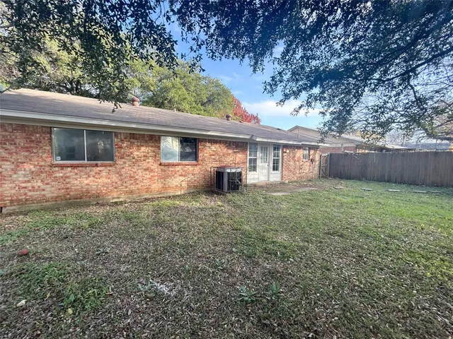 a front view of house with yard and trees in the background