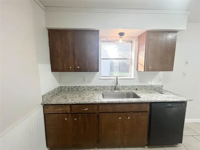 a bathroom with a granite countertop sink a mirror and cabinets