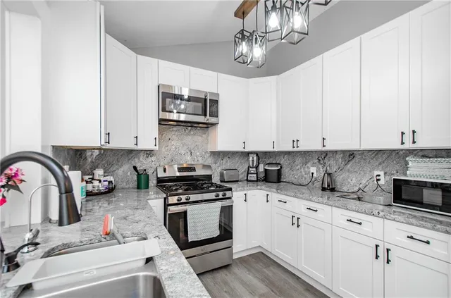 a kitchen with stainless steel appliances granite countertop a sink and stove top oven
