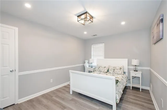 a view of a bedroom with a bed and wooden floor