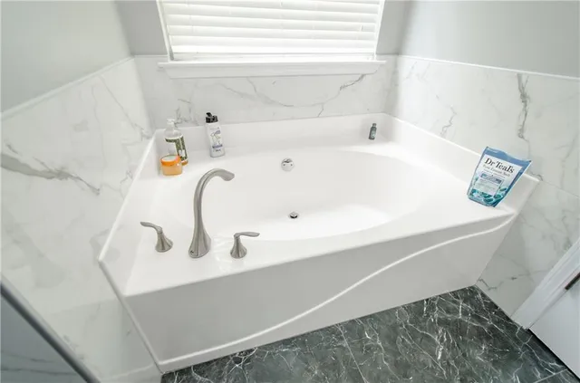 a bathroom with a bathtub and a window