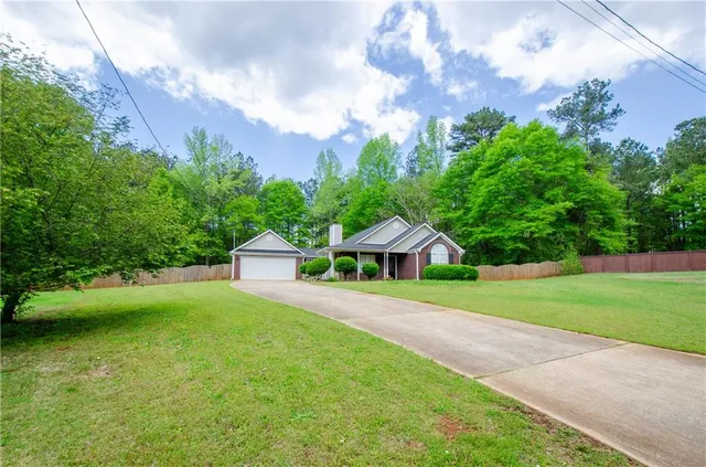 a front view of a house with a yard and trees